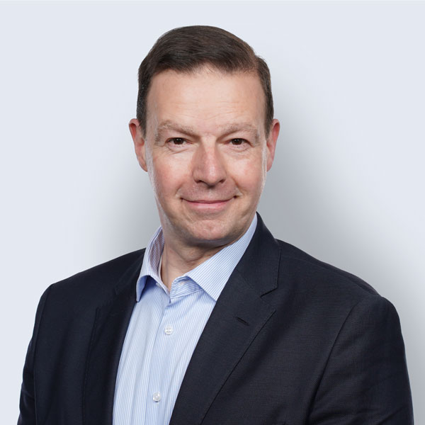 Carsten Stich im dunklen Anzug und hellblauen Hemd, leicht lächelnd – Interim Executive und Management Consultant.